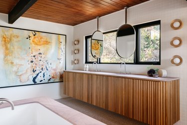 bathroom space with hanging mirrors and artwork
