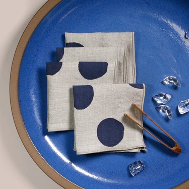 Grey cloth napkins with blue polka dots on a blue plate