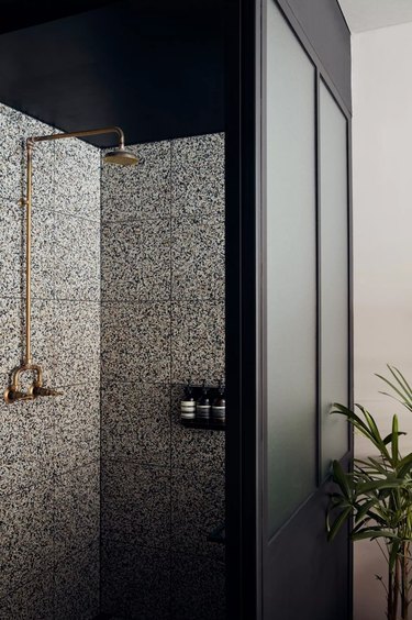 terrazzo shower walls with gold shower head