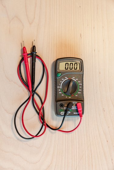 multimeter electrical tester on wood background