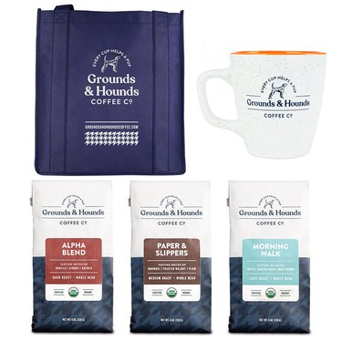 Various items from Grounds & Hounds Coffee Co. including a navy tote bag, white mug, and three bags of coffee.