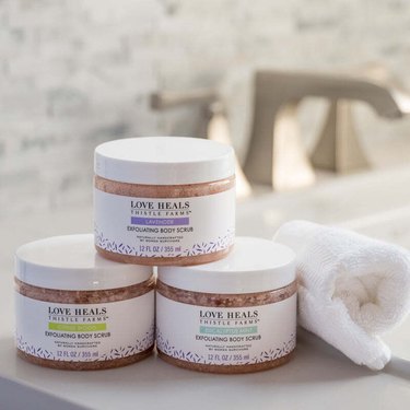 Three containers of body scrubs from Thistle Farms