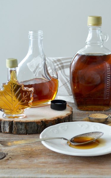 Bottles of maple syrup on a wooden table