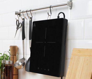 induction cooktop hanging from rack on kitchen wall