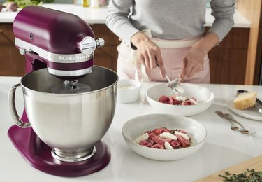 A purple-red KitchenAid mixer on a white countertop