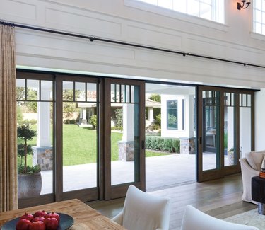 A living room with wooden multi-slide patio doors covering a large opening for the deck
