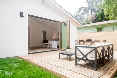 Bifold patio doors connected to a small deck with table and chairs