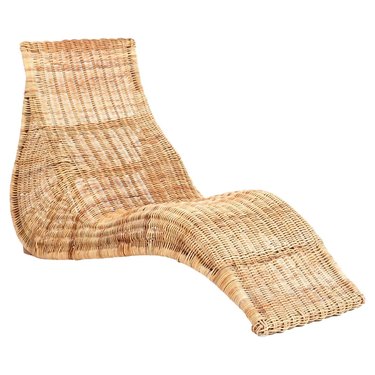 Long wicker lounge chair from IKEA  with a curved bottom on a white background.