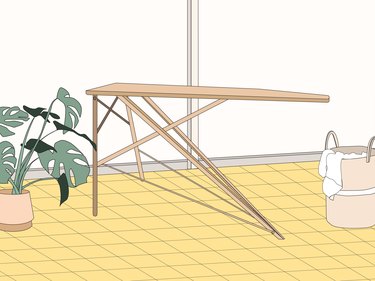 An illustration of a fold-out light brown ironing board on a yellow floor next to a basket of laundry.