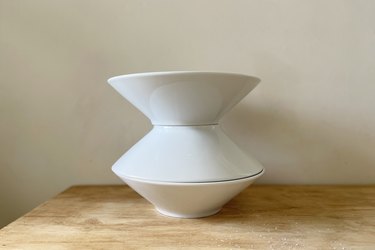 Three tapered ceramic bowls stacked to create a vase shape