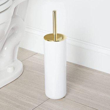 brass-handled toilet wand in white cylindrical holder