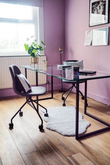 purple office walls with black desk and chairs