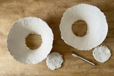 Bottom holes cut out of two paper mache bowls with a utility knife