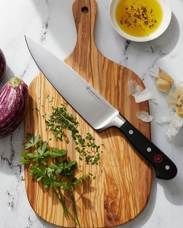 overhead view of chopping board with herbs and knife