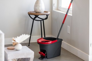 Black and red spin mop and bucket in living room