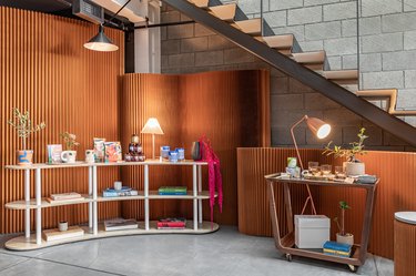 Black Spaces iteration of Hunker House showroom featuring products on shelving near stairs