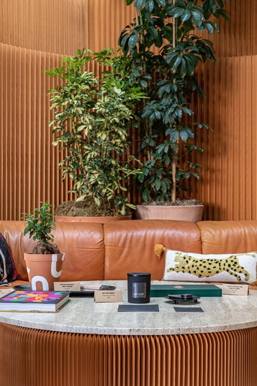 Black Spaces iteration of Hunker House showroom featuring leather sofa and coffee table with travertine top