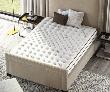 Saatva Classic Mattress on a tan bed frame in a bedroom
