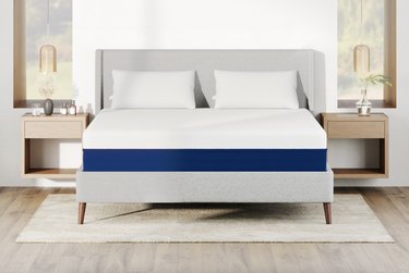 Amerisleep AS2 mattress on a gray bed frame in a bedroom with white walls