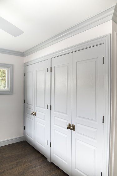 A wall of white double French closet doors that have gold handles