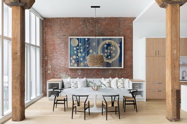 dining room with brick wall and navy blue artwork