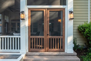 Wooden double screen doors on the entrance of a porch