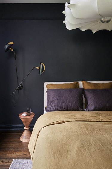 black bedroom with brown and purple bedding