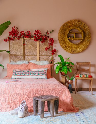 peach boho bedroom with rattan headbaord and mirror, coral bedspread
