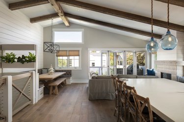 Kitchen with tables and chairs with vaulted ceiling and shiplap white accent wall
