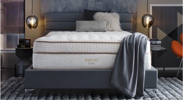 Gray bed frame with white mattress and gray blanket
