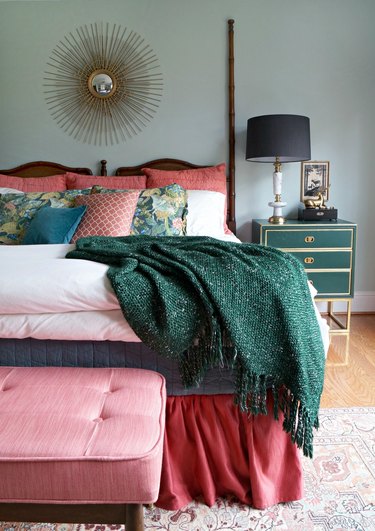 dusty green luxe bedroom with coral soft furnishings