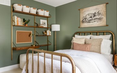 Bedroom with sage green walls and a brass bed