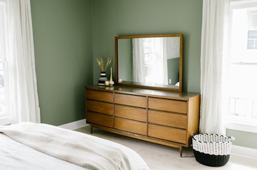 Bedroom with sage green walls and wood dresser