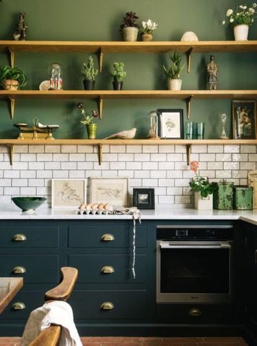 Kitchen with sage green walls and deep green cabinets.