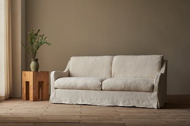 Sixpenny Esme Sofa in white in a living room with green walls