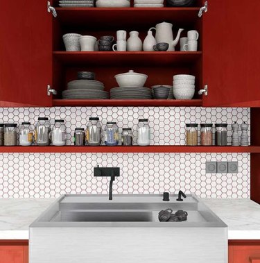 Kitchen with red cabinets, white nickel tile backsplash, red grout, apron sink.