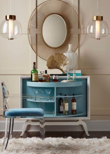 Bar cabinet, chair, mirror, pendant lights, glassware, vase, rug.