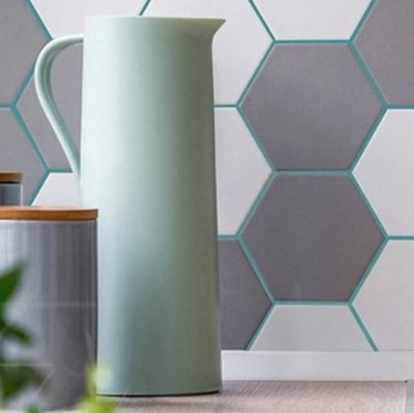 Kitchen backsplash with gray and white hex tile, turquoise grout.