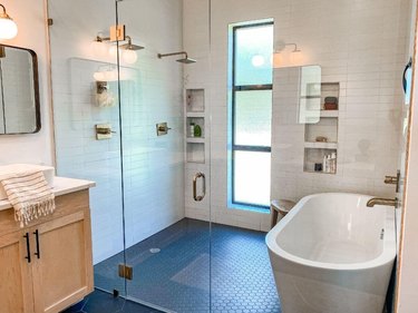 Wet room with two showerheads and a bathtub