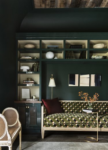 Home office featuring an olive green couch and forest green walls
