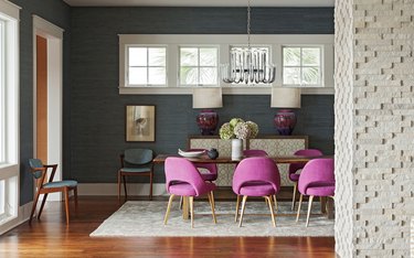 dining room with fuchsia chairs and gray grasscloth