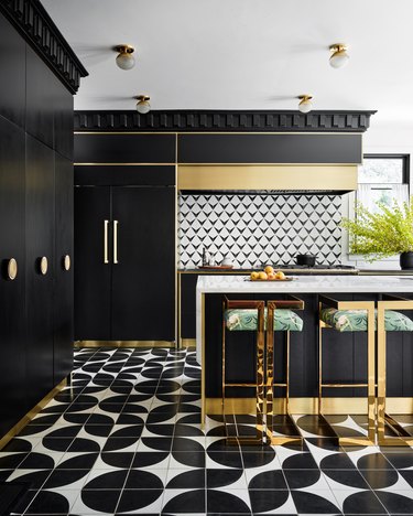 Black and white graphic kitchen with gold accents by Maestri Studio