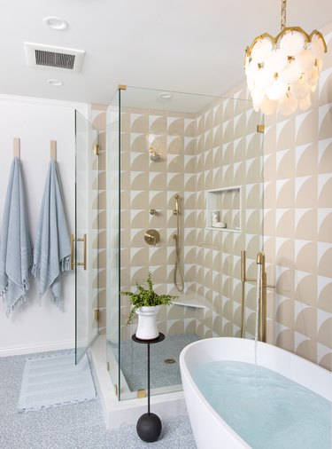 Bathroom design with beige tile and gold accents