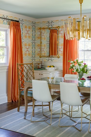 Dining room with orange curtains and gold details