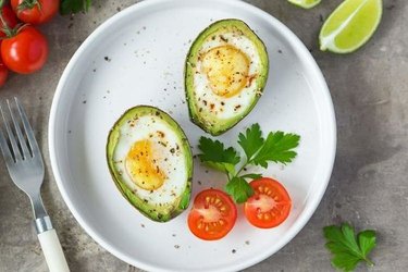 Baked avocado eggs on a white plate