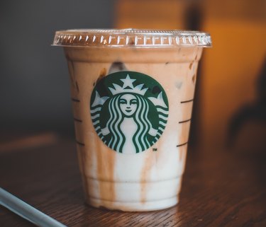 Image of an iced Starbucks drink with the logo on a wooden surface.