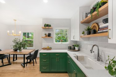 Kitchen designed by JLK Interiors with green cabinetry and gold accents