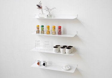 Set of 4 floating white shelves with assorted items on each