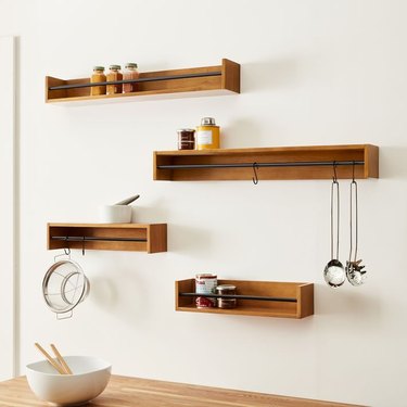 4 floating wooden shelves with black bar hardware on each