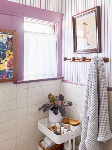 cream tile bathroom wall with purple striped wallpaper